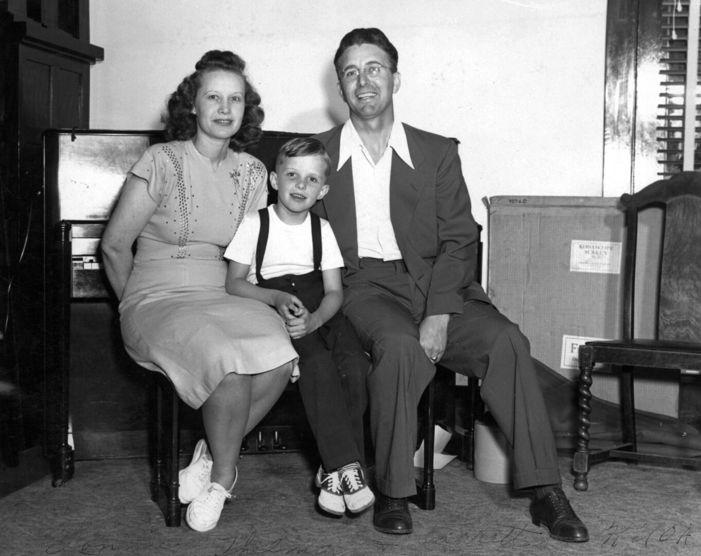 A man and woman sitting next to a young boy.