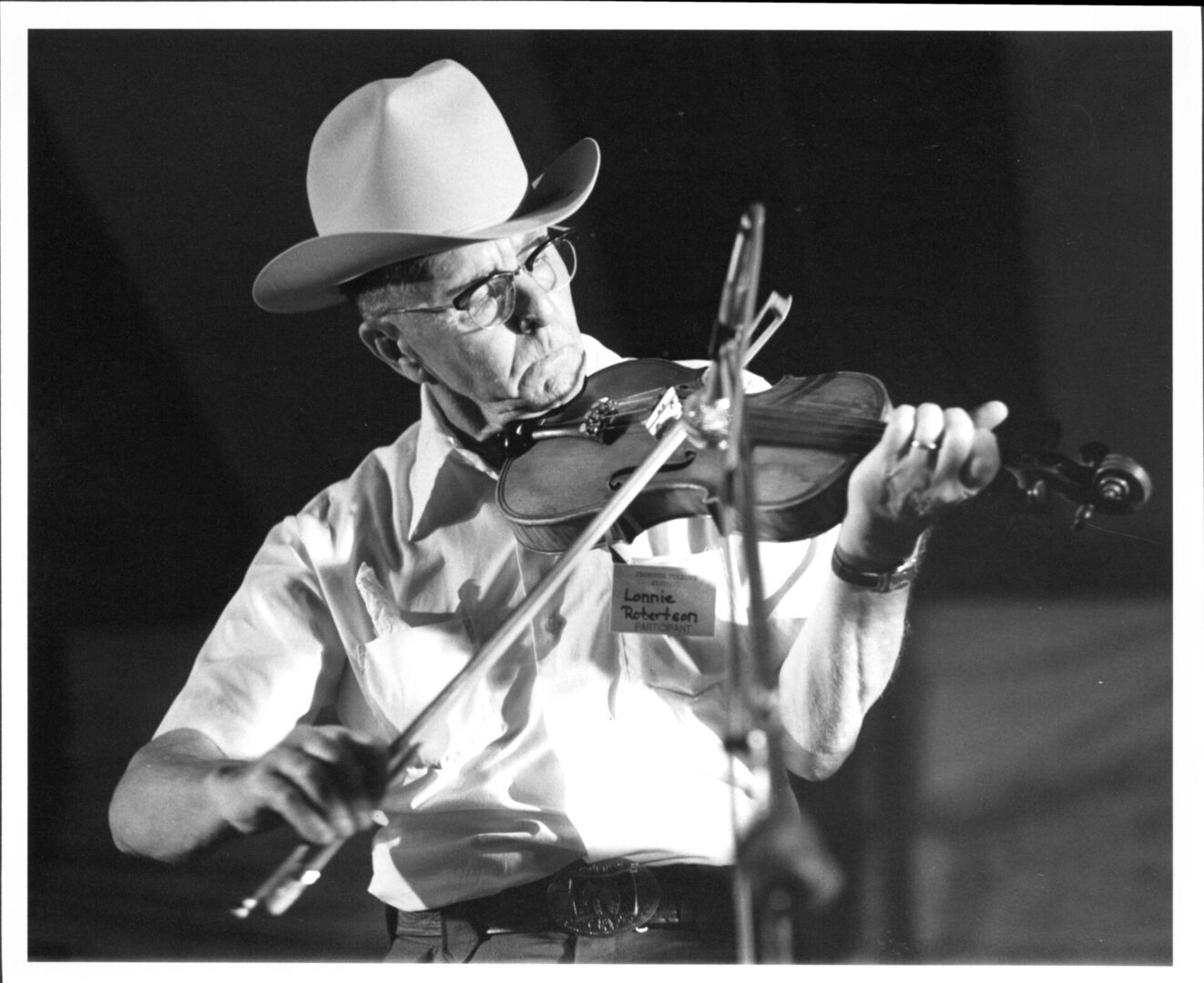 A man playing the violin in front of an audience.
