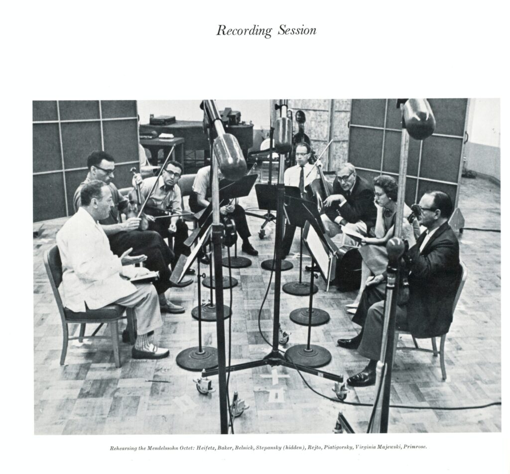 A group of people sitting around in a recording studio.