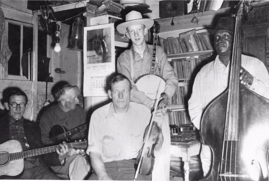 The calendar in the photo dates it as February of 1954. Saturday Night on the Ozark Square in Ozark, Missouri. Located in the Emanuel Wood's second-hand store.<br>
Emanuel Wood, Fiddle
<br>
Byron Kelley, Bass Fiddle
<br>
Leslie Haguewood, Banjo
<br>
Jude Herndon, Guitar (dark wood guitar)
<br>
Tom Church, Guitar (light wood guitar)
