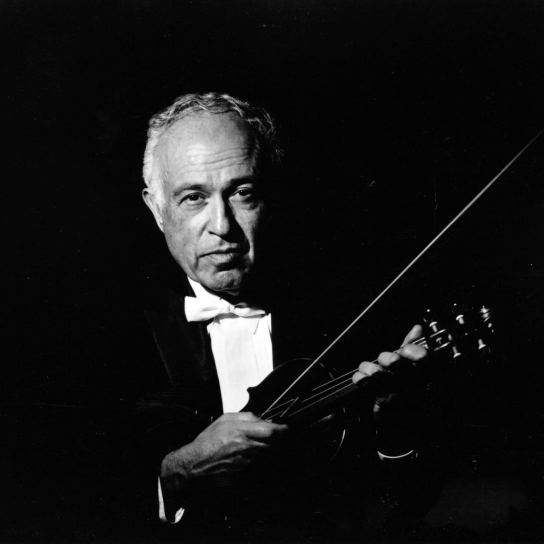 A man in black and white holding a violin.